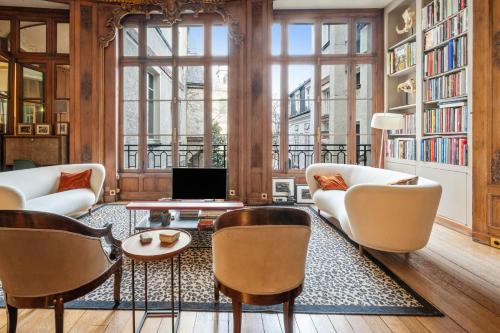 Elle comprend un salon doté d'un mobilier blanc et de grandes fenêtres. dans l'établissement Appartement Mewes - Welkeys, à Paris