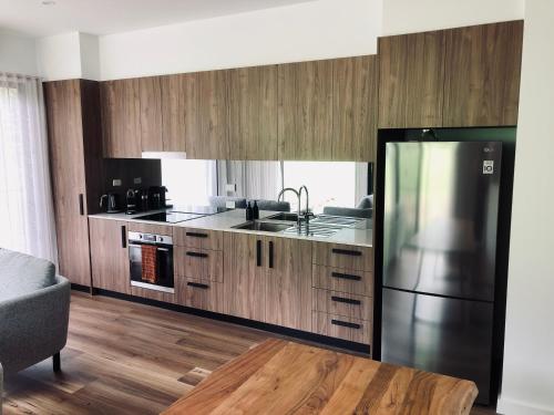 a kitchen with wooden cabinets and a stainless steel refrigerator at Selah Valley Estate in Limpinwood