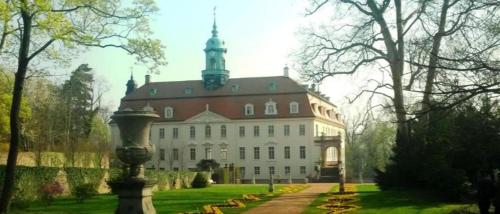 ein großes Gebäude mit einem Turm darüber in der Unterkunft Zum stillen Himmelbett in Niederwiesa