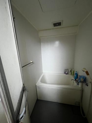 a small bathroom with a tub and a sink at Big houz in Sendai
