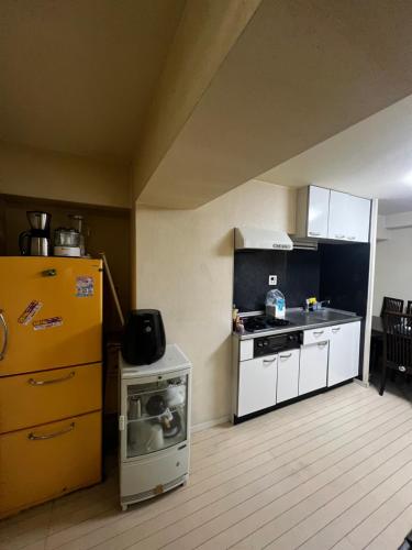 a kitchen with a yellow refrigerator and a stove at Big houz in Sendai