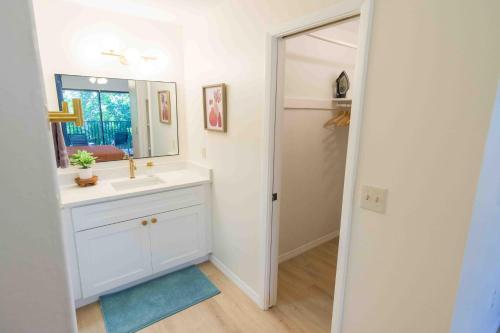 a white bathroom with a sink and a mirror at Private Tropical Beach Oasis in Cape Canaveral