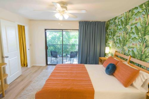een slaapkamer met een groot bed en een balkon bij Private Tropical Beach Oasis in Cape Canaveral