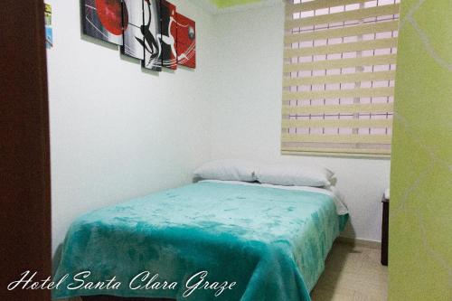 - une chambre avec un lit et une couverture bleue dans l'établissement Hotel Santa Clara Graze, à Pasto