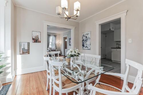 a dining room with a glass table and white chairs at Grace's Place - 3 Bedroom Townhouse in Greenwich in Greenwich