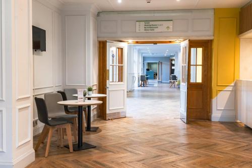 un couloir avec une table et des chaises dans un bâtiment dans l'établissement Holiday Inn Doncaster A1- M Jct 36, an IHG Hotel, à Doncaster