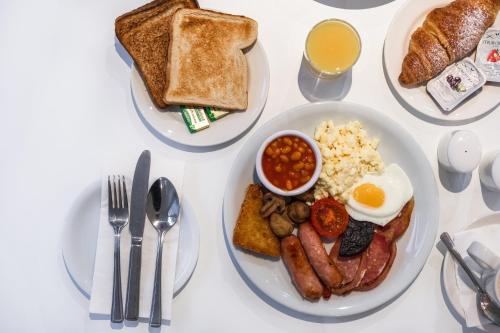 a table with a plate of breakfast food with eggs sausage and toast at Holiday Inn Doncaster A1- M Jct 36 by IHG in Doncaster
