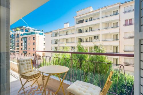 a balcony with a table and chairs and a building at Brand new 2 bedroom in the heart of Cannes in Cannes