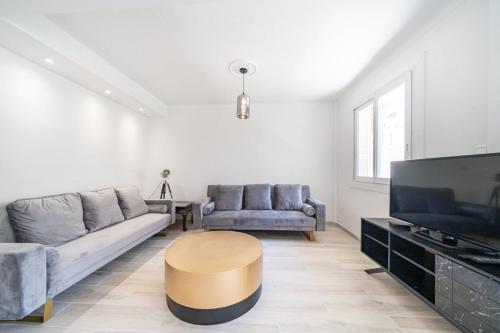 un salon avec un canapé, une table et une télévision dans l'établissement Brand new 2 bedroom in the heart of Cannes, à Cannes