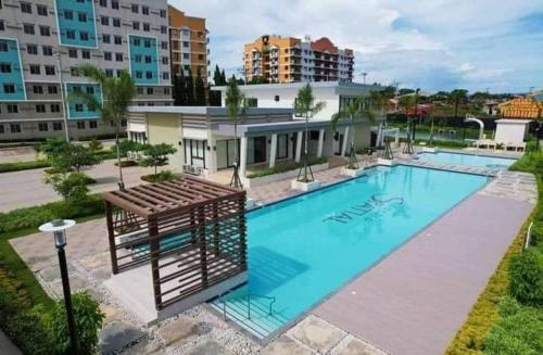 a large swimming pool in a city with buildings at Entire 2BR condo Centro Spatial Downtown in Davao City