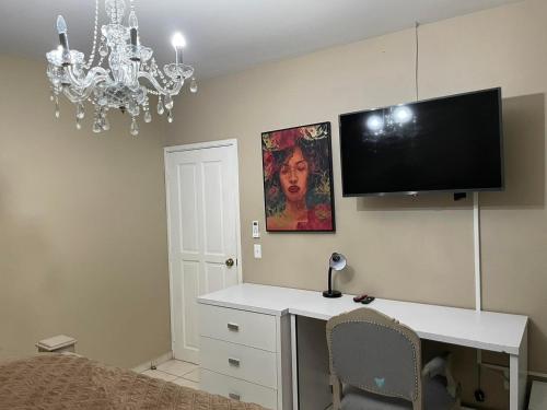 a room with a desk and a tv on a wall at Quinta Vela Hotel in Tegucigalpa