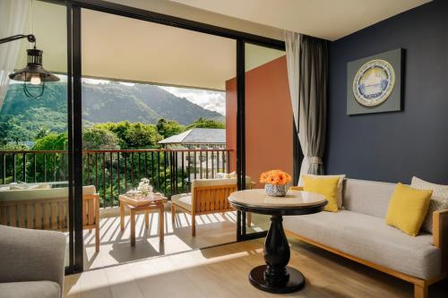a living room with a couch and a table at Avista Grande Phuket Karon - MGallery in Karon Beach