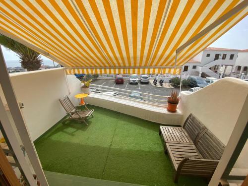 a balcony with two benches and a view of a street at Oasis del sur, sea view los cristianos in Los Cristianos