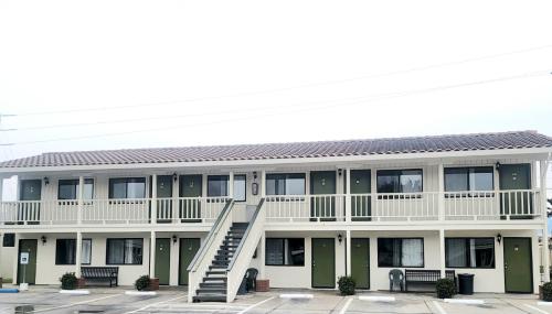 an apartment building with a staircase in a parking lot at Soledad Motel 8 in Soledad