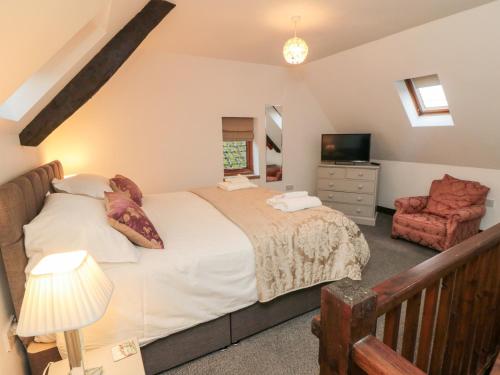 a bedroom with a large bed and a chair at Mill Cottage in Whitby