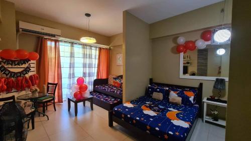 a bedroom with a bed and a table and balloons at Pico de Loro Staycation (3 beds- 6 pax) in Nasugbu