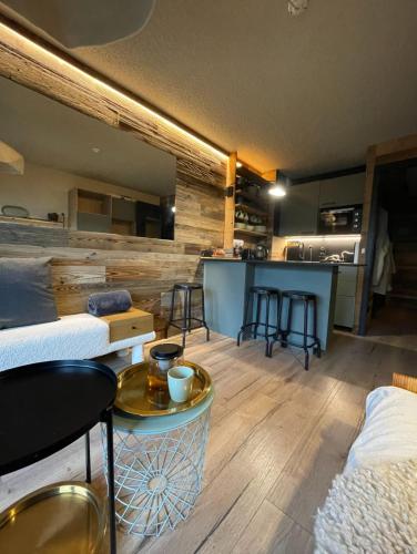 Habitación con cama y bar con taburetes en Charming studio with terrace and garden, en Praz-sur-Arly