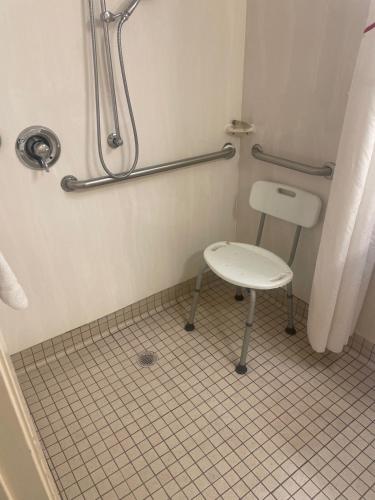 a bathroom with a chair and a shower at Red Roof Inn Dallas - DFW Airport North in Irving