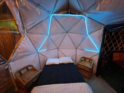 una camera con un letto e due sedie in un igloo di Mirador de la Montaña Glamping a San Francisco