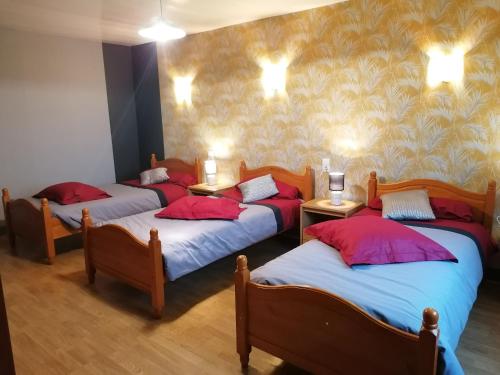 um quarto com 4 camas com almofadas vermelhas e azuis em Gîte Bais, 4 pièces, 7 personnes - FR-1-600-19 em Bais