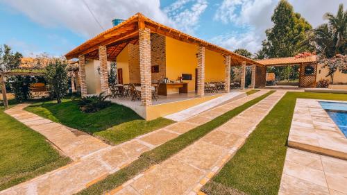 a house with a pool and a yard at Pousada Sítio Machado in Viçosa do Ceará