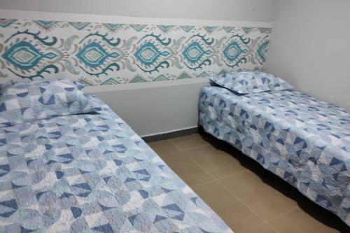 dos camas sentadas una al lado de la otra en una habitación en Wana casa 4 -Requinte e Conforto, en São José do Rio Preto