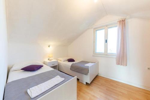 um quarto branco com 2 camas e uma janela em Holiday house with a swimming pool Kotlenice, Zagora - 22219 em Dugopolje