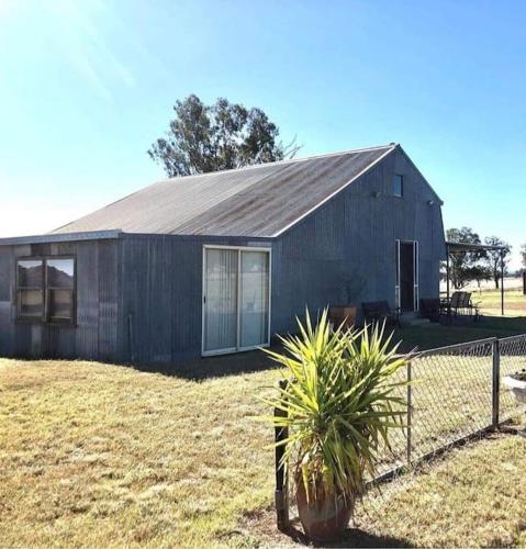 a house with a fence in front of it at Gorgeous Country Woolshed in Loomberah