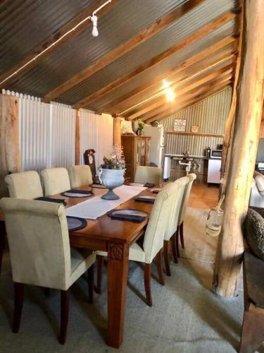 a dining room table with white chairs and a tableablish at Gorgeous Country Woolshed in Loomberah