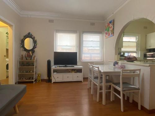 a kitchen with a table and a television in a room at 2 bedroom small unit 1 minute walk to shopping centre NO PARKING SLOT NO LIFT in Wollongong