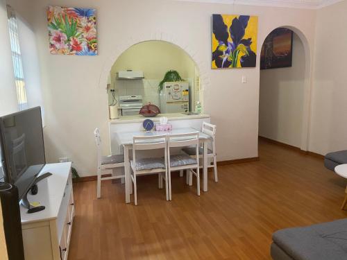 a living room with a table and a kitchen at 2 bedroom small unit 1 minute walk to shopping centre NO PARKING SLOT NO LIFT in Wollongong