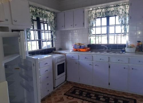 a kitchen with white cabinets and a stove top oven at R&G Residential in Roseau