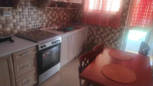 a kitchen with a table and a sink and a stove at COMFORTABLE BEACHFRONT APARTMENT in Loutraki
