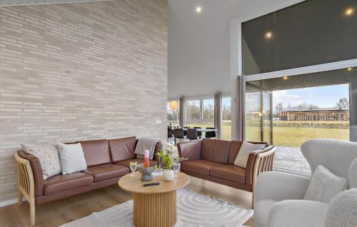 a living room with two couches and a table at 4 Bedroom Cozy Home In Hadsund in Hadsund