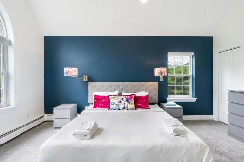 a bedroom with a large bed with a blue wall at Malkita Aria Mountainview Retreat in Woodbury