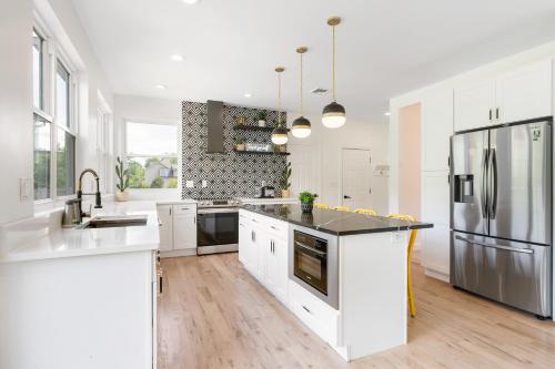 a kitchen with white cabinets and a stainless steel refrigerator at Malkita Aria Mountainview Retreat in Woodbury