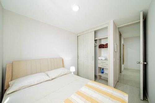 Dormitorio blanco con cama y armario en Modern and Cozy apartment, en Sabaneta
