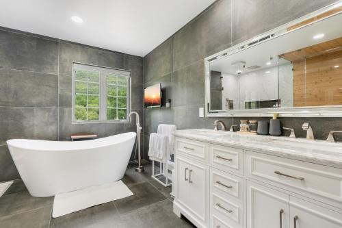 a bathroom with a tub and a large mirror at Malkita’s Mountain View Villa in Woodbury