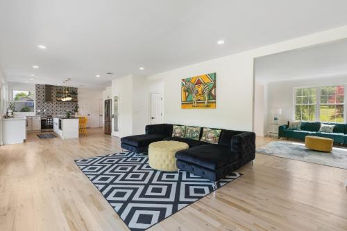 a living room with a black couch and a rug at Malkita Aria Mountainview Retreat in Woodbury