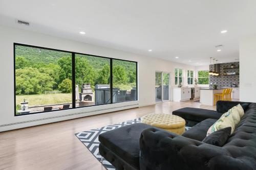 a living room with black furniture and large windows at Malkita Aria Mountainview Retreat in Woodbury