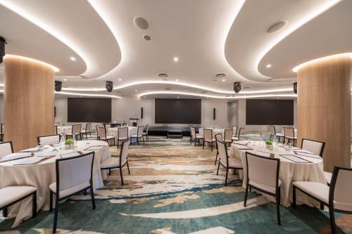 a conference room with tables and chairs and a projection screen at Crowne Plaza Changi Airport by IHG in Singapore