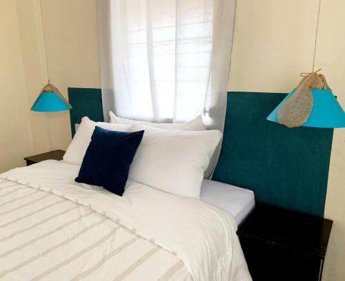 a bedroom with a bed with white and blue pillows at Hostal Casa Antigua Santa Ana in Santa Ana