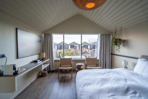a bedroom with a bed and a large window at The Hill Hotel at Flúðir in Fludir