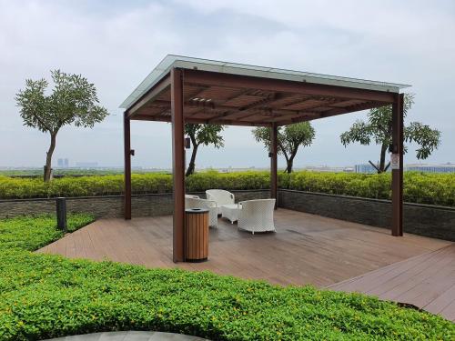 a gazebo with a table and chairs on a wooden deck at 2BedRooms Apartment in Gold Coast PIK in Jakarta