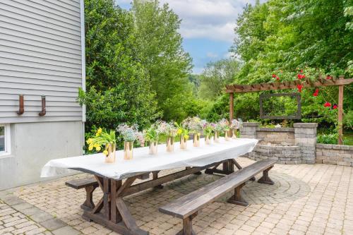 a long white table with benches and flowers on it at Malkita Aria Mountainview Retreat in Woodbury