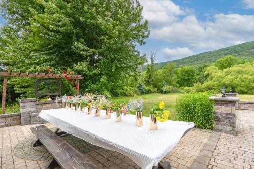 a long white table with flowers in vases on it at Malkita Aria Mountainview Retreat in Woodbury