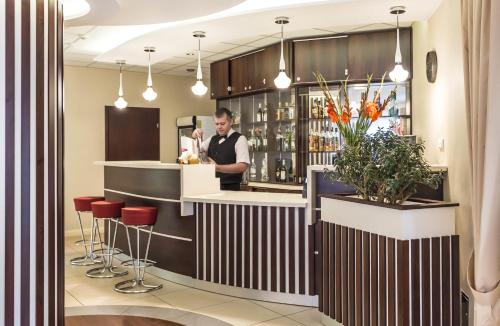 a man standing at a bar in a restaurant at Hotel Justyna in Kraków