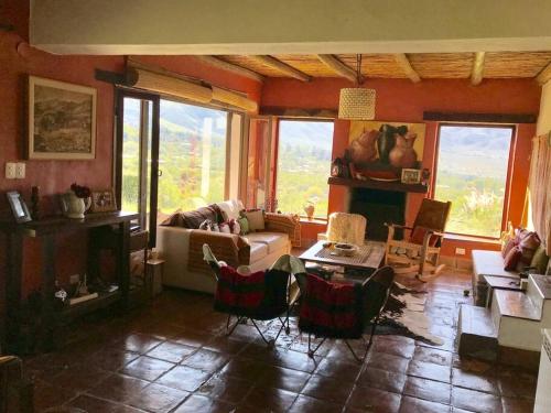 - un salon avec un canapé, une table et des chaises dans l'établissement La Escondida Tafi del Valle, à Tafí del Valle