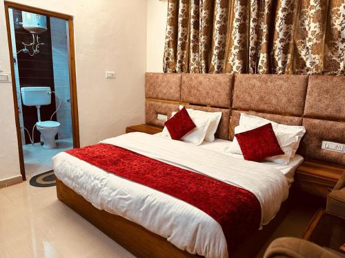 a bedroom with a large bed with red pillows at The Aston Hills - A Luxury Stay , Shimla in Shimla