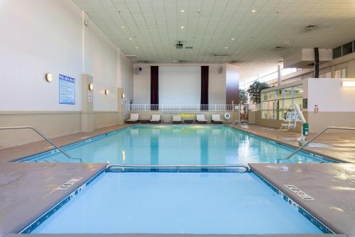 a large swimming pool with blue water in a building at Ramada by Wyndham Boise in Boise